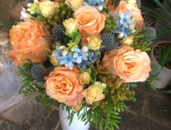 83 - Kulatá svatební kytice z meruňkových růží, modrých poměnek a modrého eryngia